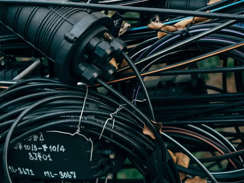 A dome splice closure among coiled black drop cables